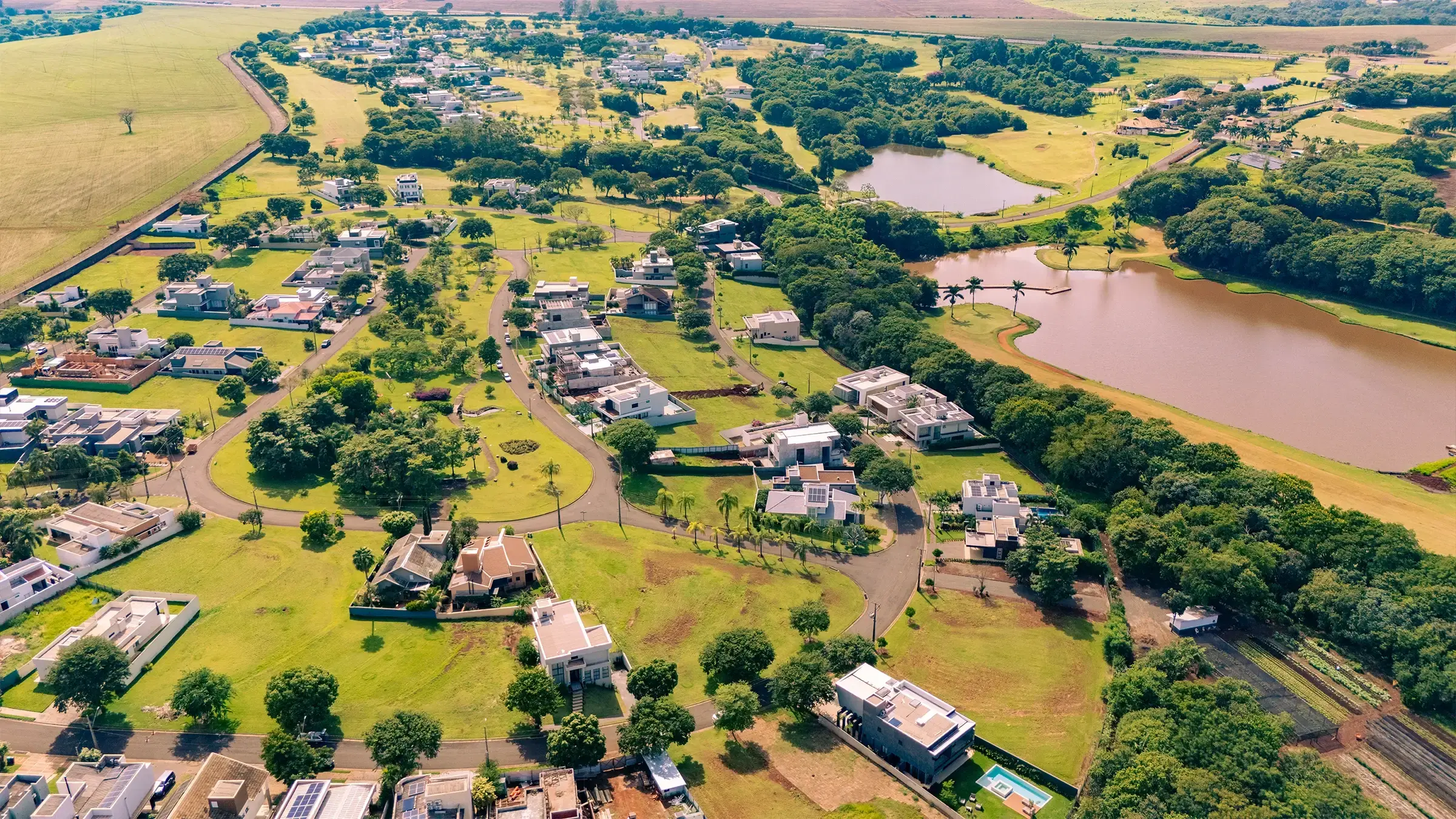 Vista aérea do bairro Alphaville Maringá, com casas, lagos e áreas verdes